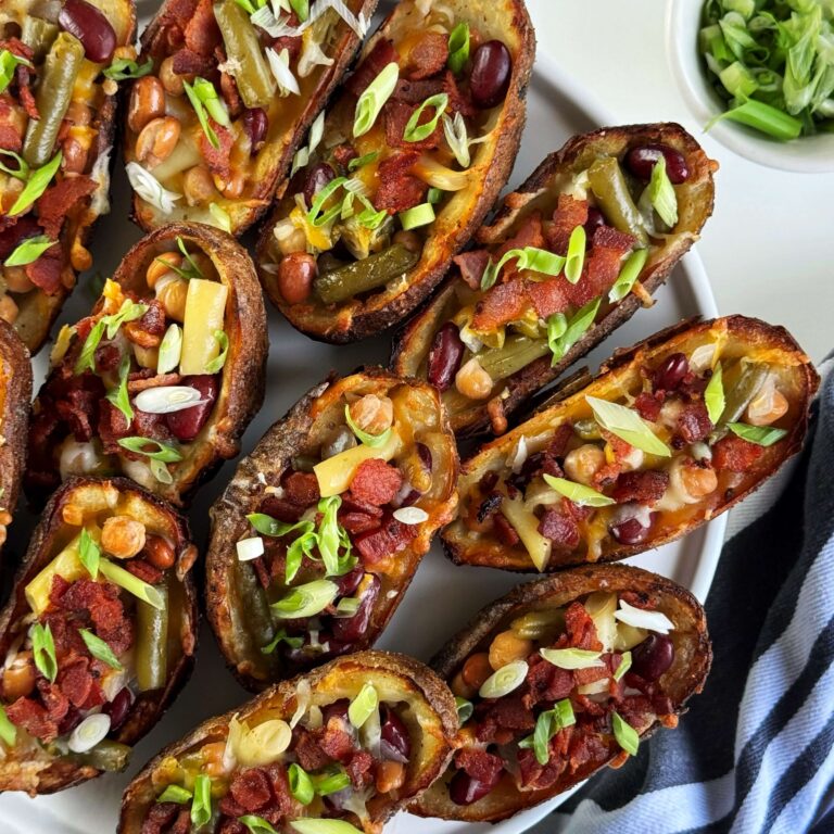 Potato skins stuffed with Five Bean salad on a black plate.