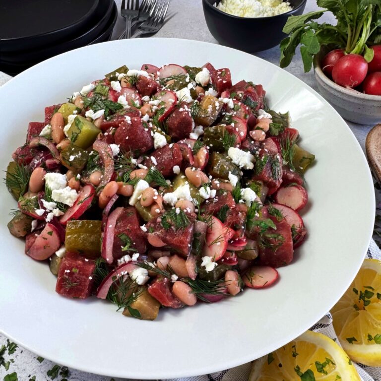 A white plate with Herbed Sweet Beet Salad with Dill Pickles and Cannellini Beans
