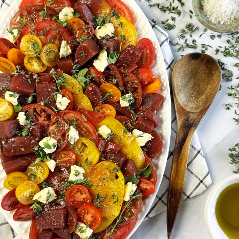 White bowl with Balsamic Beet and Tomato Salad and a wooden spoon