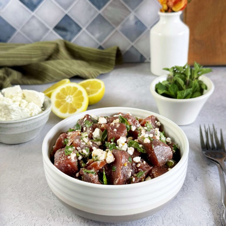 A white dinner bowl with Balsamic Beets, fresh herbs and Feta Cheese