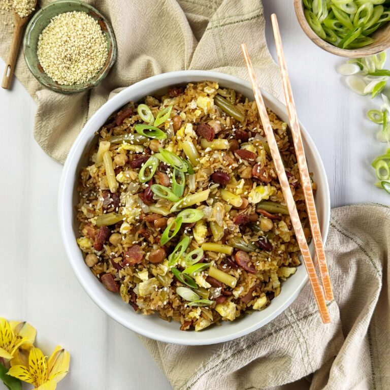 A white bowl of Five bean salad and bacon fried rice with chop sticks.
