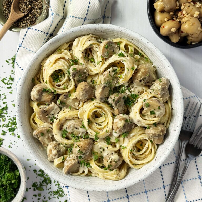 A white bowl of Marinated Mushroom Fettuccini Alfredo