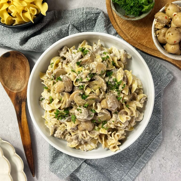 Mushroom and Ground Beef Stroganoff in a white bowl with a wooden spoon.