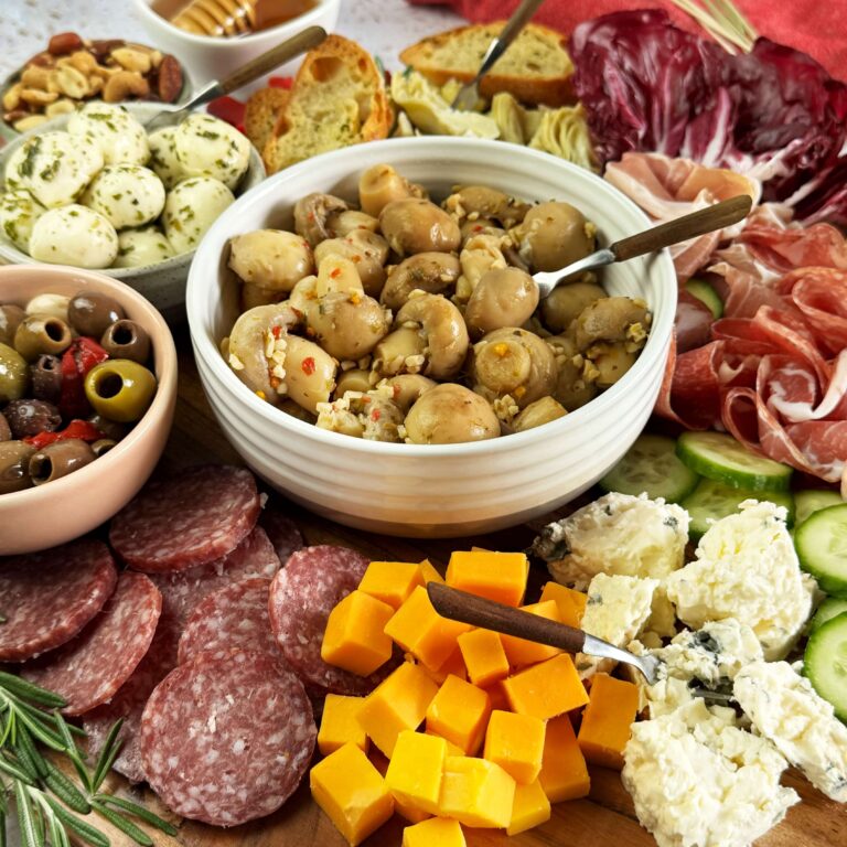 Marinated Mushroom Charcuterie Board on a wooden round tray.