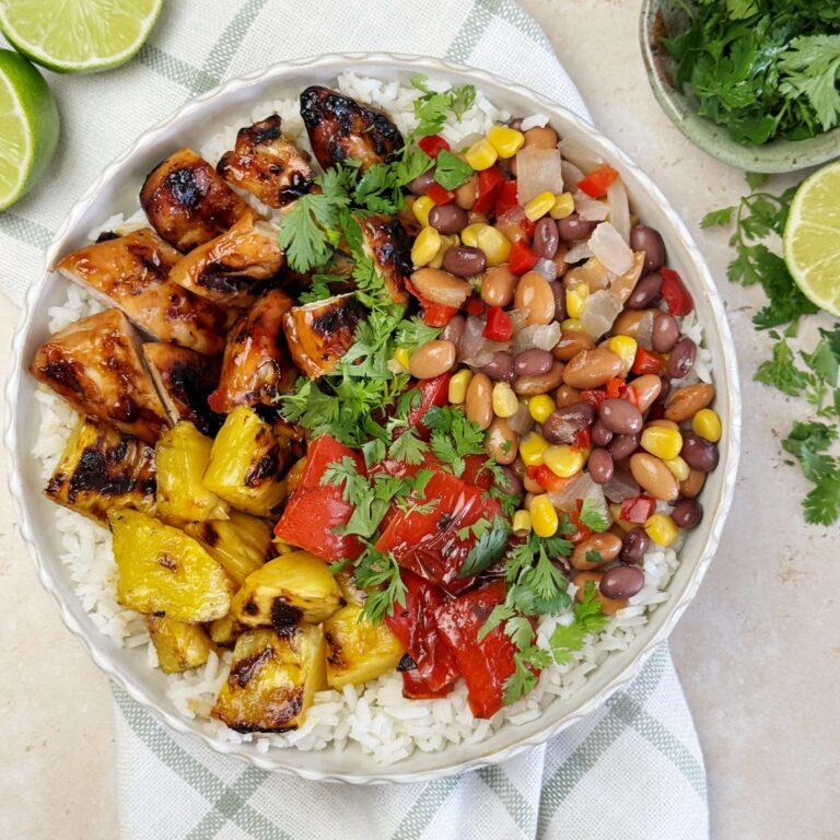 A white dinner plate with Hawaiian - inspired Grilled ChickenPineapple Bowls with Cowboy Caviar